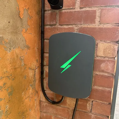 Wall-mounted EV charger with its ready light on, a typical job for our electrician in Kings Norton