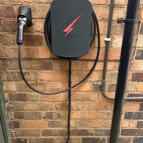 Tethered EV charger with cable clipped neatly along the wall