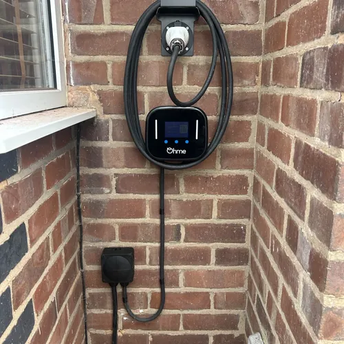 Ohme smart EV charger with the cable stored neatly on its holster